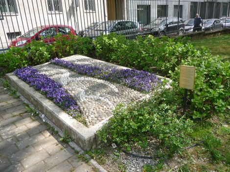 Memoriale con rose e violette in un giardino, in omaggio ai bambini di Neuengamme.