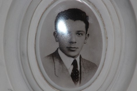 Fotografia in bianco e nero di un giovane uomo con cravatta e giacca, incorniciata in un ovaletto.