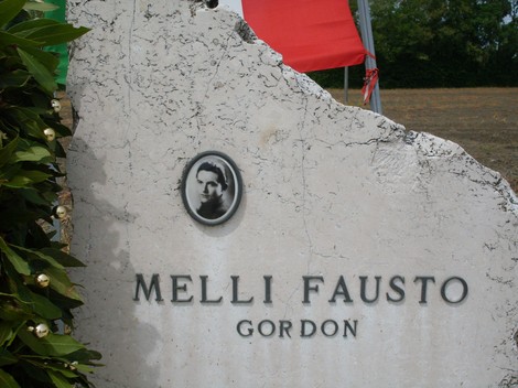 Cippo commemorativo dedicato a Fausto Melli, con foto e nome incisi sulla pietra.