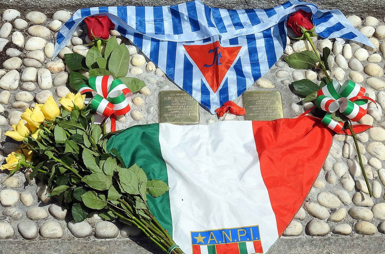 Pietre d'inciampo dedicate a Locatelli e Panigadi, con fiori e simboli nazionali in memoria delle vittime.