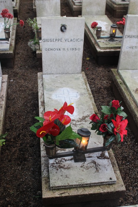 Tombe decorate con fiori su un cimitero, dedicate ai caduti per la Libertà. Atmosfera di rispetto e ricordo.