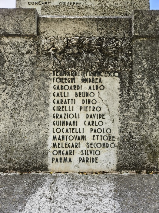Monumento ai Caduti con iscrizioni in memoria dei soldati, ornato da elementi decorativi in pietra.