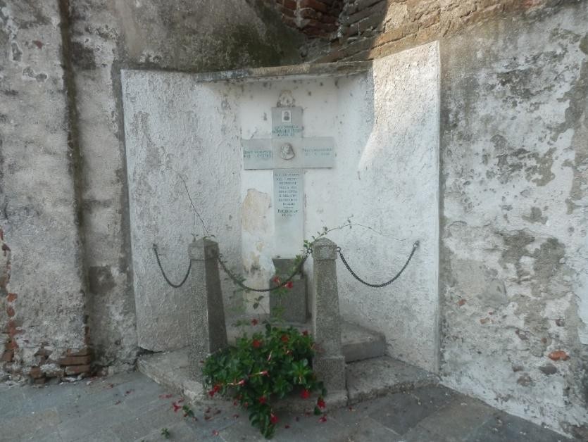 Croce a Marchese, monumento storico con decorazioni floreali, situato in un'area rustica e suggestiva.