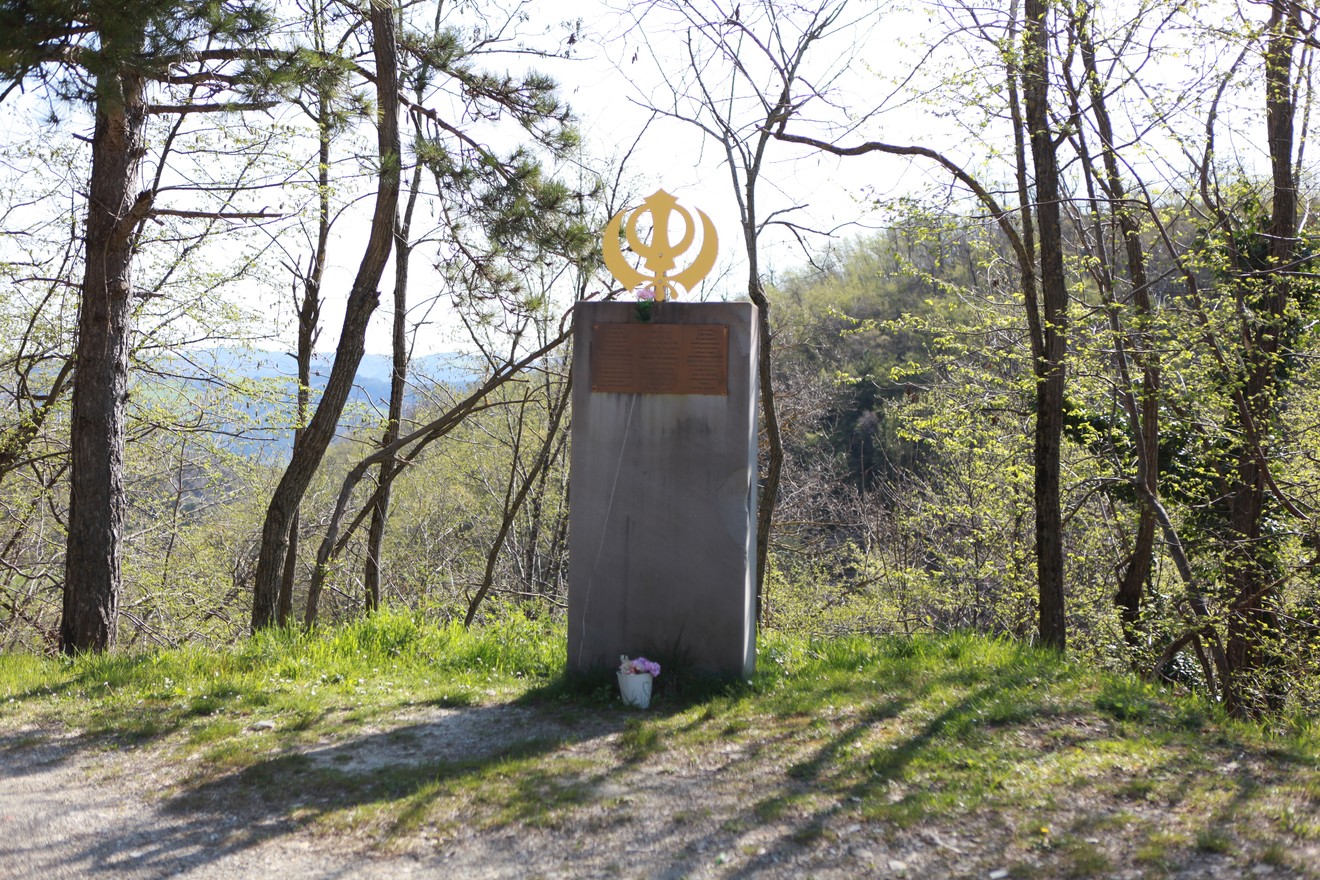 Monumento commemorativo immerso nella natura, dedicato alla Battaglia della Cavallara, con vegetazione circostante.