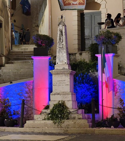 Monumento ai caduti di Canterano, illuminato con luci colorate, in una pittoresca piazza.