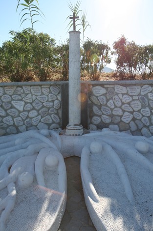 Monumento delle Fosse del Frigido, simbolo di memoria e riflessione, circondato da una natura rigogliosa.