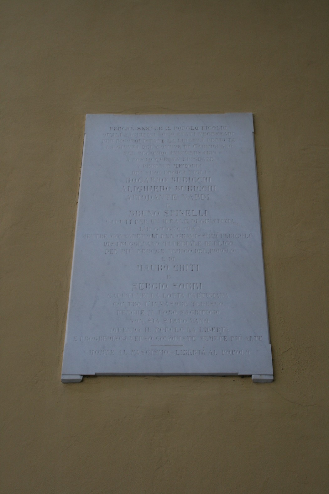 Lapide commemorativa affissa al municipio, dedicata alla memoria di eventi significativi.