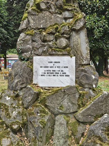 Monumento ai Caduti di Stagno Lombardo, dedicato ai soldati delle guerre, posizionato in un contesto naturale.