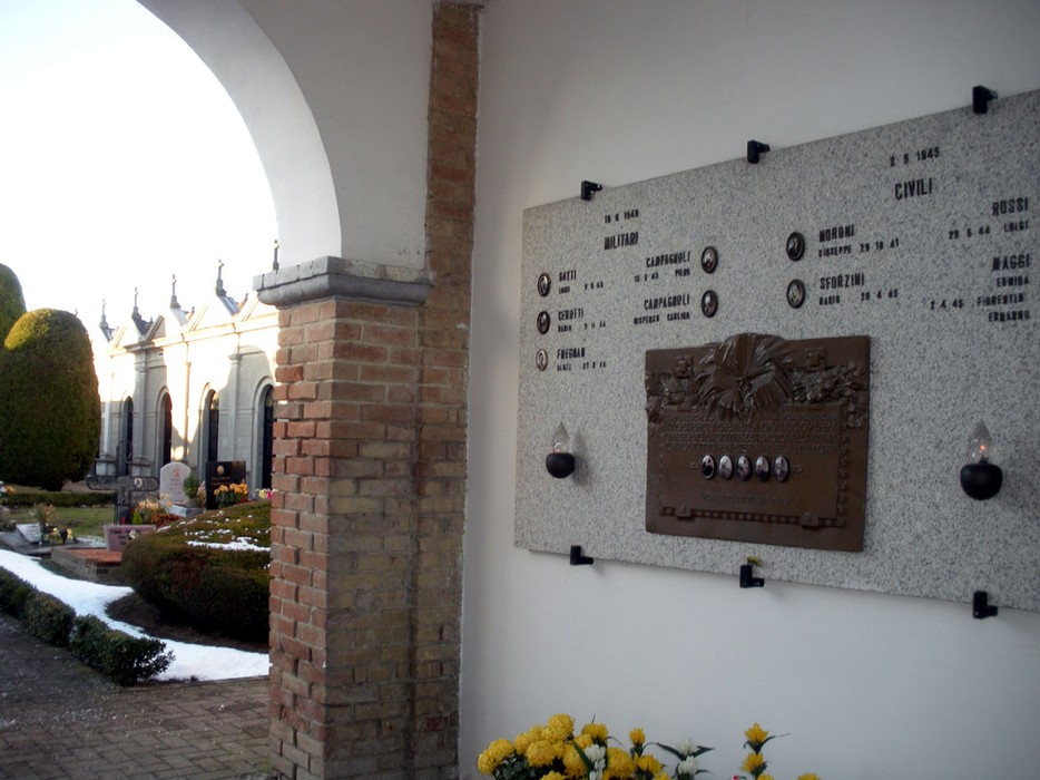 Lapide commemorativa ai caduti di Verretto, situata nel cimitero del paese, con decorazioni floreali.