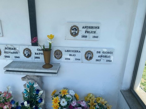 Interno della Cappella dei caduti per la libertà, con decorazioni floreali e nomi di caduti su lapidi.