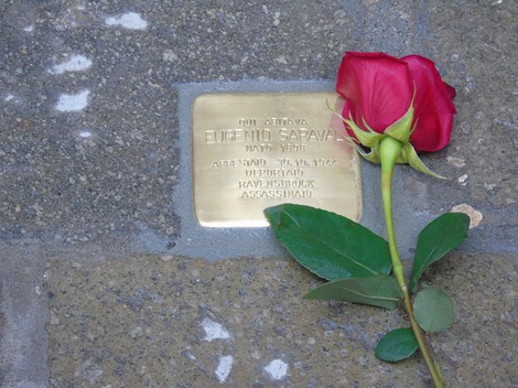 Pietra d'inciampo dedicata a Eugenio Saraval, con una rosa rossa accanto, in memoria del deportato.