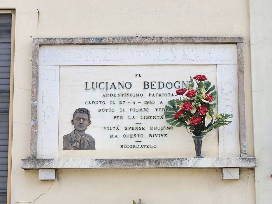 Lapide commemorativa a Luciano Bedogni, patriota ardimentoso, con inserto floreale e dedica alla libertà.