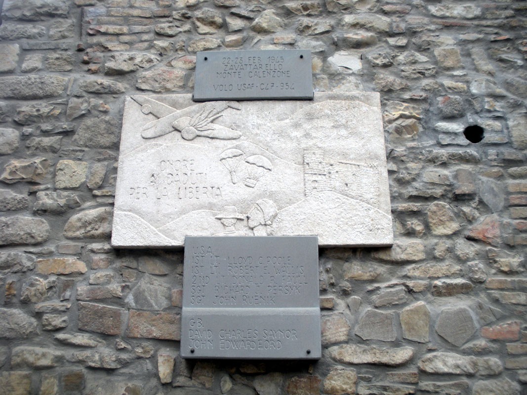 Lapide commemorativa agli avieri alleati, simbolo di libertà e sacrificio, su muro di pietra.