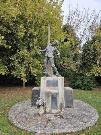 Monumento ai Caduti di Dogato, Libolla e San Vito, con statua e fiori, immerso nel verde.