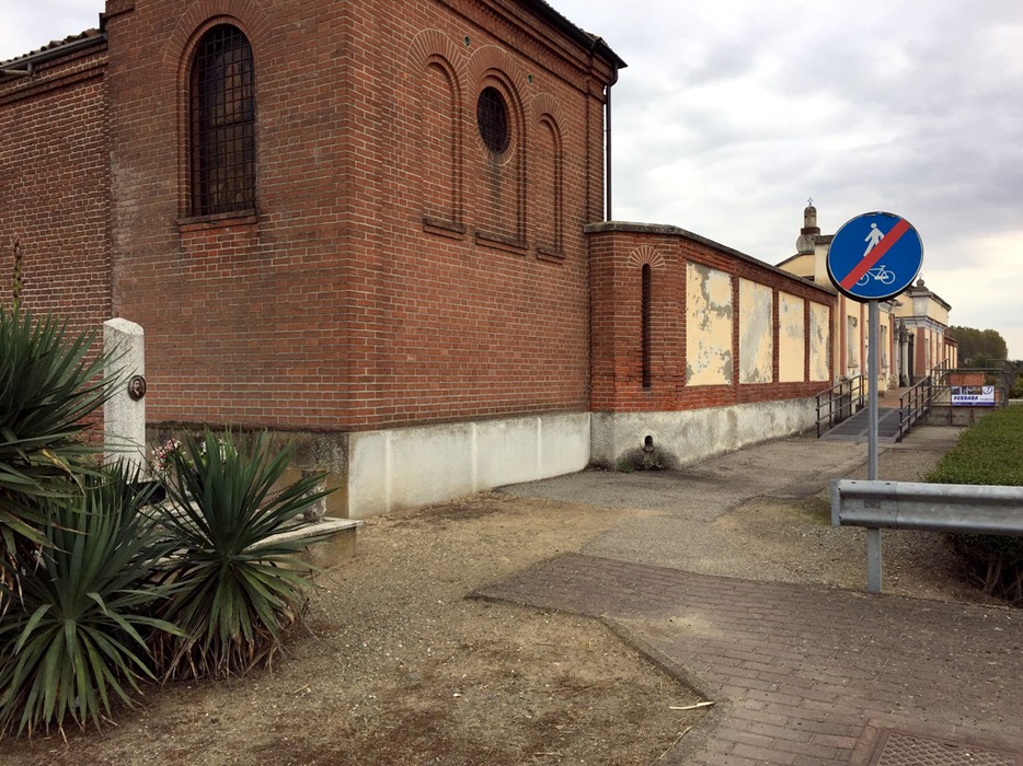 Cippo a Genestrone, un monumento storico circondato da edifici e vegetazione.