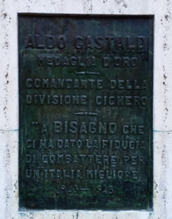 Monumento commemorativo a Gastaldi, in marmo, con iscrizioni dedicate al comandante e alla sua storia.