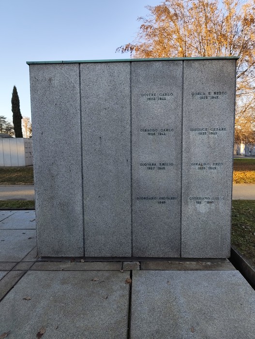 Monumento commemorativo con nomi incisi su lastre di pietra, immerso in un contesto urbano elegante.