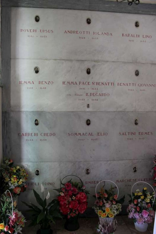 Sacrario dei caduti per la libertà di Cavezzo, con lapidi commemorative e fiori in omaggio.