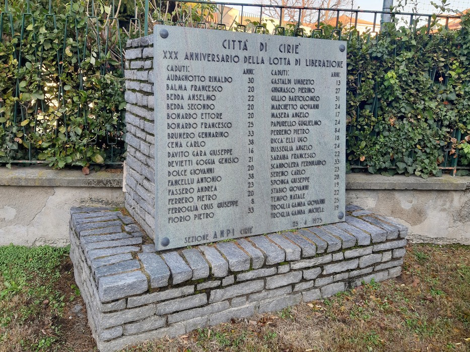 Monumento commemorativo con nomi di caduti e dettagli sul "XXX Anniversario della Lotta di Liberazione".