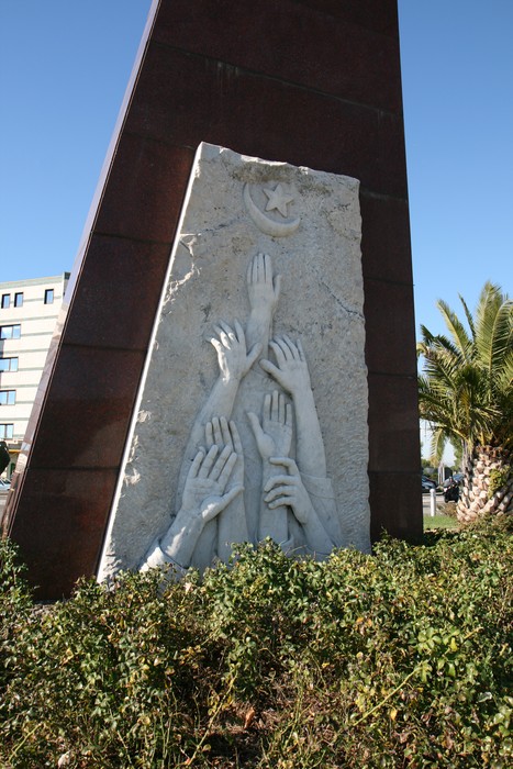 Monumento che simboleggia il ricordo delle vittime delle stragi in Apuania, con mani in preghiera e speranza.