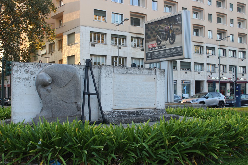 Monumento al Corpo dei Volontari della Libertà, con base monumentale e sfondo urbano ricco di vegetazione.
