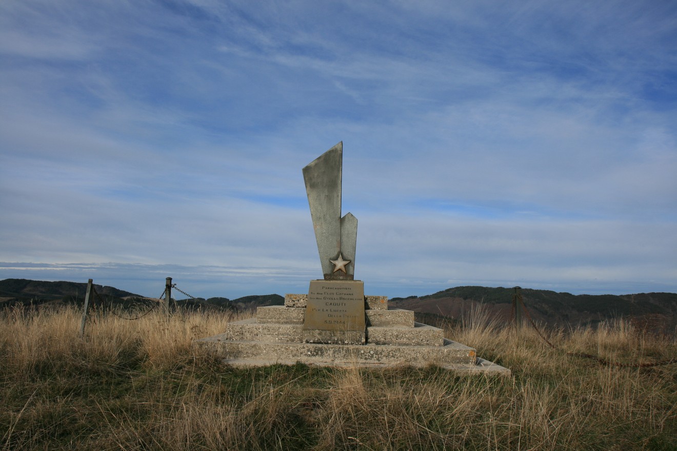 Monumento di Monte Pomponi, commemorativo, incastonato in un paesaggio naturale, con struttura in metallo e pietra.
