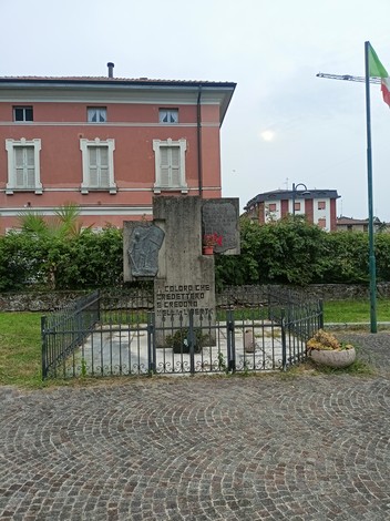 Monumento alla Resistenza, un'area commemorativa con una struttura in pietra e decorazioni nel verde.