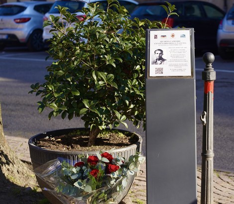 Stele commemorativa a Camurri con fiori, in ricordo di una figura significativa della storia locale.