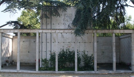 Monumento ai Caduti Partigiani, struttura in cemento con vegetazione e un design sobrio e commemorativo.