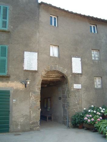 Lapide di Calamecca, antico edificio con ingresso caratteristico, circondato da vegetazione.