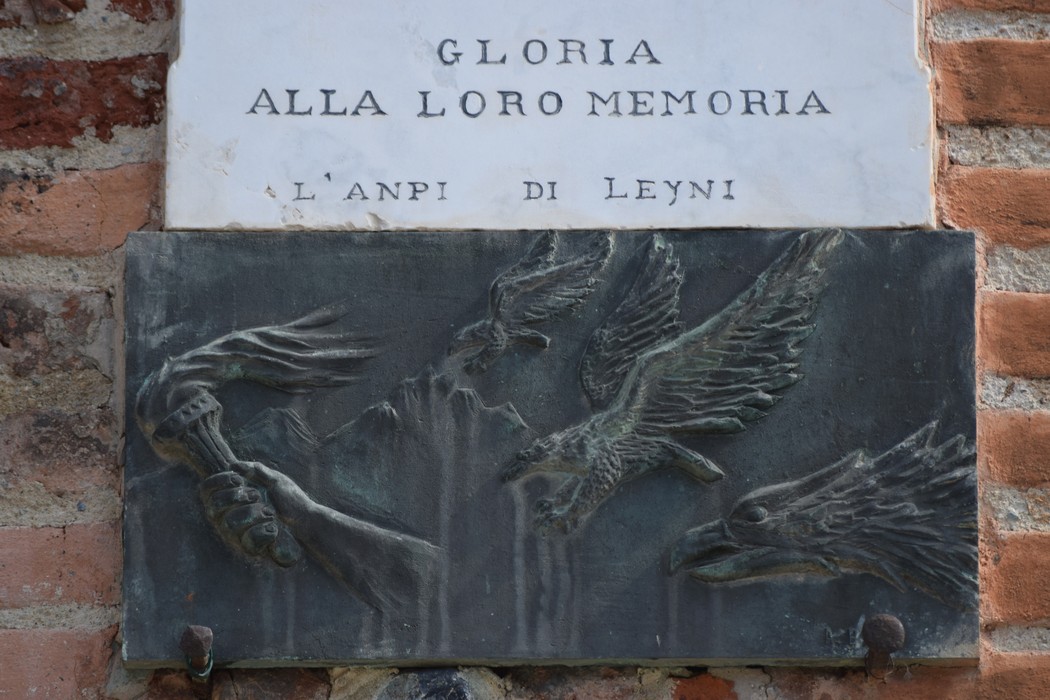 Lapide commemorativa con incisioni di simboli di libertà e resistenza. Omaggio ai caduti per la libertà.
