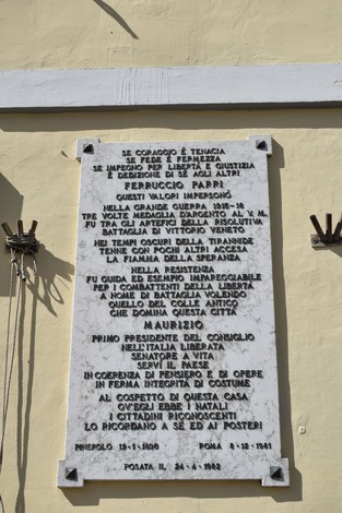 Lapide commemorativa dedicata a Ferruccio Parri, con riferimenti alla sua vita e opere durante la Resistenza.