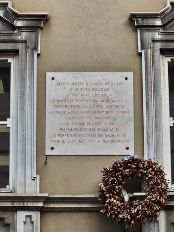 Lapide commemorativa dedicata ai martiri di via Ghega, situata su un edificio storico.