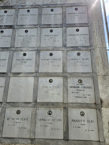 Monumento ai Caduti Partigiani con targhe commemorative di eroi della Resistenza.