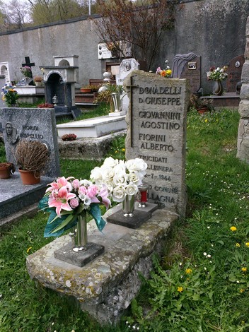 Sacrario di Donadelli, Fiorini e Giovannini, con fiori e lapide commemorativa in un cimitero.