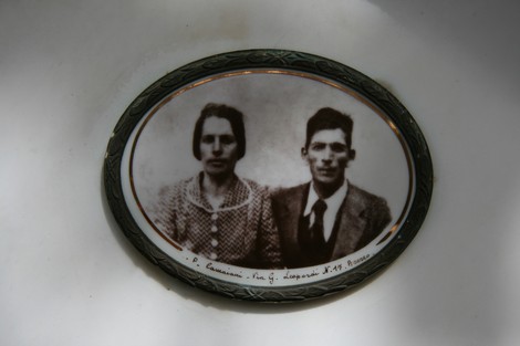 Lapide commemorativa della famiglia Buzzini con un'immagine di due persone in posa.