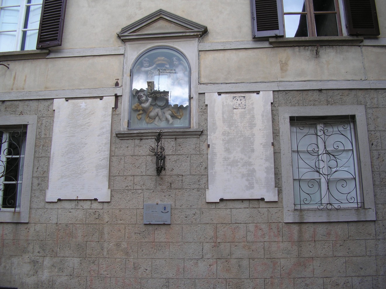 Lapidi commemorative sulla facciata del Municipio, con decorazioni e dettagli architettonici.