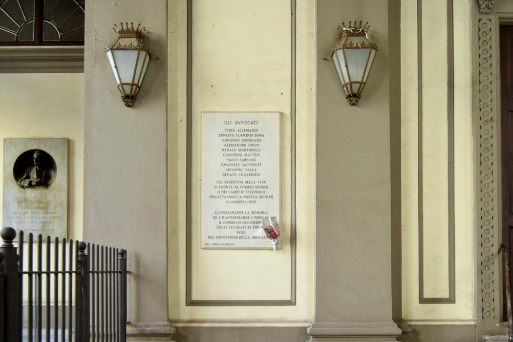 Lapide commemorativa dedicata agli avvocati caduti o internati, situata in un contesto architettonico.