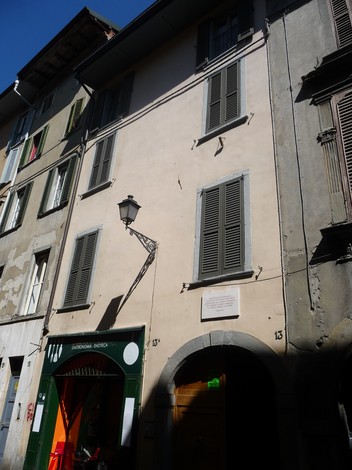 Lapide commemorativa dedicata alla Banda Turani su un edificio caratteristico in via cittadina.