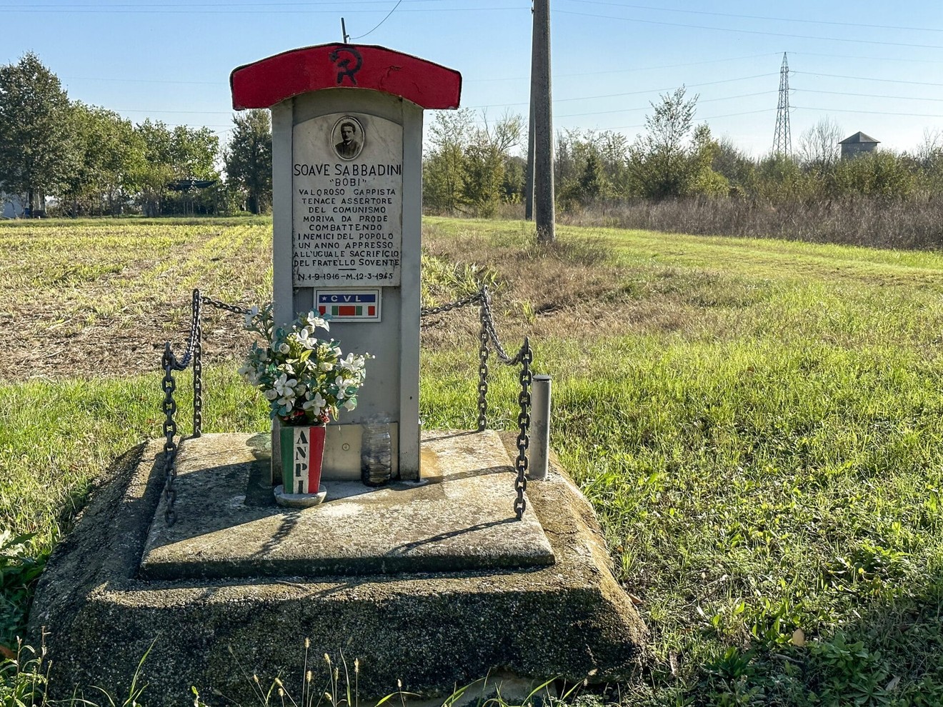 Monumento a Sabbadini, tributo a una figura storica, con fiori e una stele commemorativa.