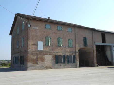 Lapide commemorativa dedicata alla famiglia Epimio Bonini su un edificio storico di mattoni.