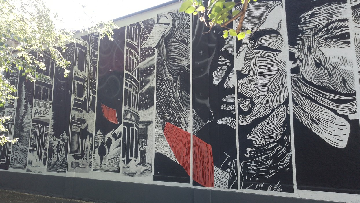 Murale colorato che celebra i "Ragazzi di Via Botticelli" con volti e dettagli architettonici.