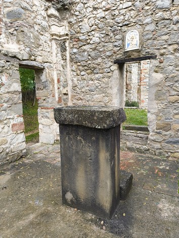 Rovine dell'oratorio di Cerpiano, con resti di muratura e un basamento al centro dell'antica struttura.