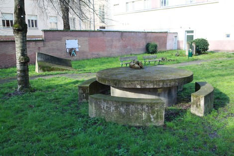 Vista del Monumento alla Resistenza, con una struttura circolare in pietra circondata da erba verde.