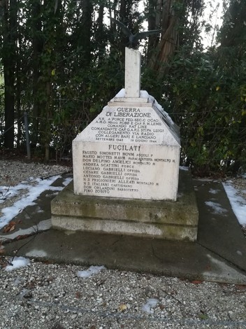 Monumento commemorativo dedicato al gruppo Stipa, con iscrizioni su base in pietra e sfondo verdeggiante.
