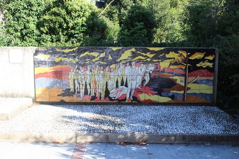 Monumento alla Resistenza rappresenta un'opera murale con figure stilizzate su sfondo colorato, simbolo di memoria storica.