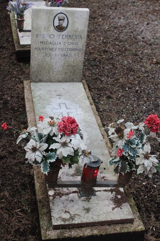 Tombe perpetue dei caduti per la Libertà con decorazioni floreali e lumino commemorativo.