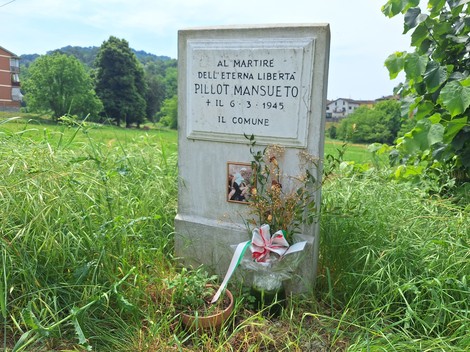 Cippo commemorativo a Pillot, dedicato al martire della libertà, immerso nella vegetazione circostante.
