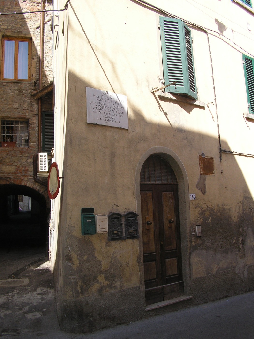 Lapide commemorativa dedicata al professor Bellucci, situata su un edificio storico.