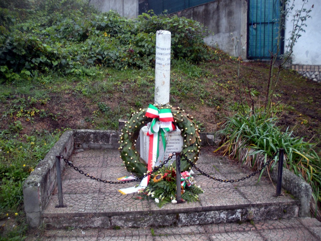 Cippo commemorativo con corona di fiori, situato a Brignoli in onore di Clerici, Gemelli e Longa.